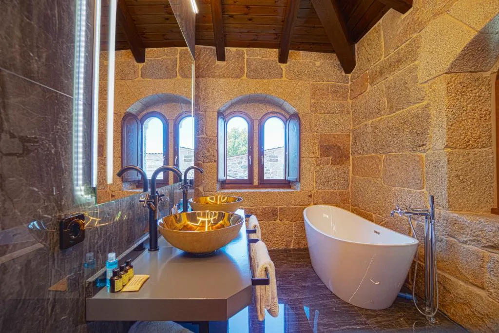 Bañera exenta bajo ventanas de arco de piedra, Hotel As Torres da Hermida