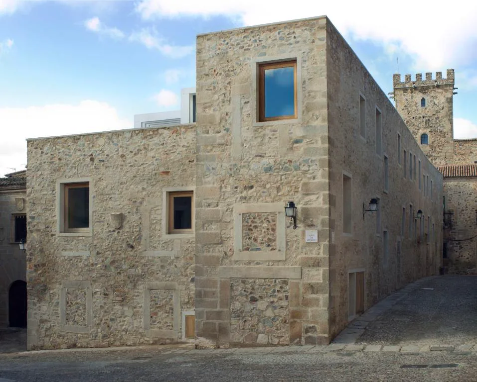 Fachada de piedra del hotel con ventanales modernos