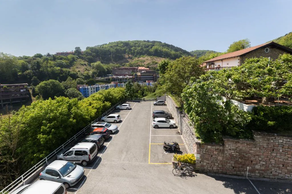 Aparcamiento y colinas verdes junto al hotel