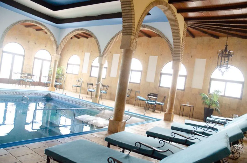 Piscina interior del balneario bajo arcos y vigas de madera