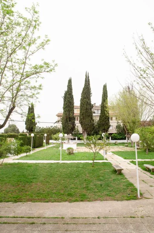 Jardín con césped y cipreses del balneario