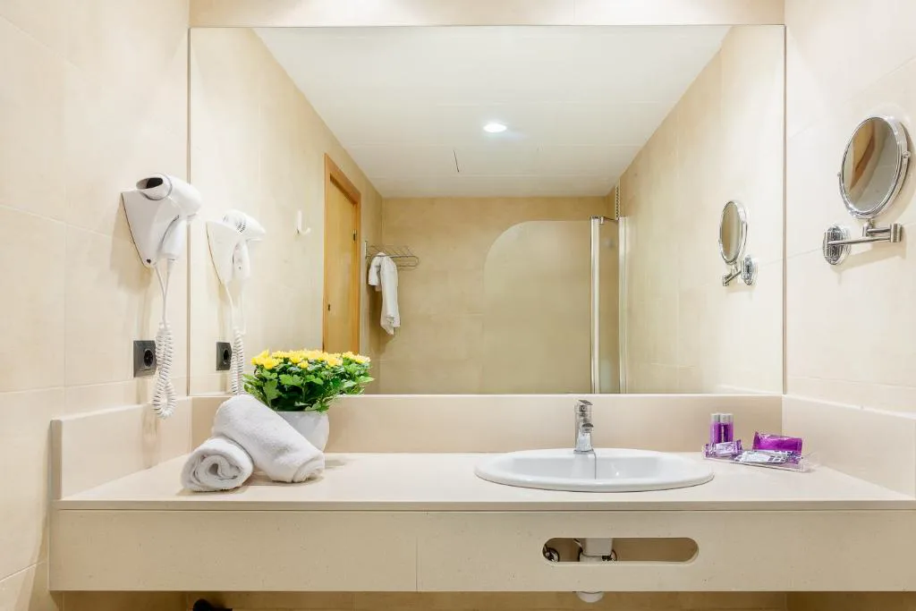 Baño con espejo y albornoces