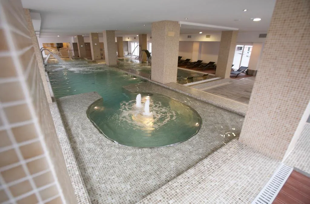 Piscina interior con jacuzzi circular y surtidores de agua, Hotel Bienestar Moaña