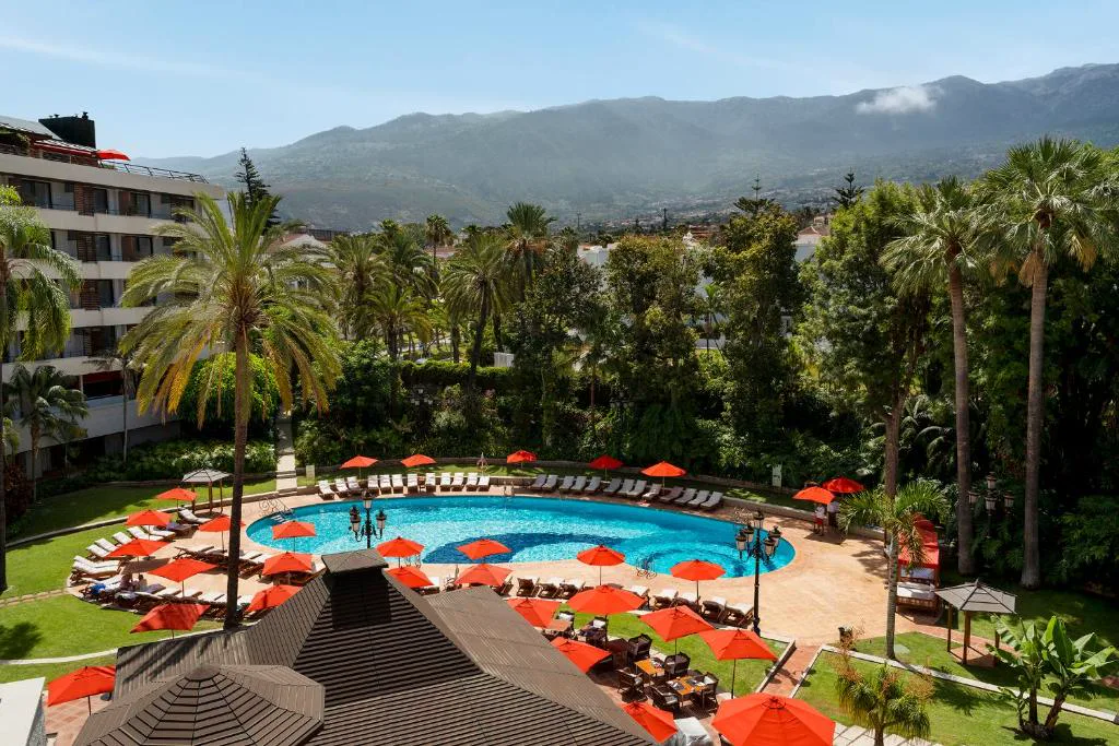 Estanque verde con puente de madera y vegetación tropical, Hotel Botanico