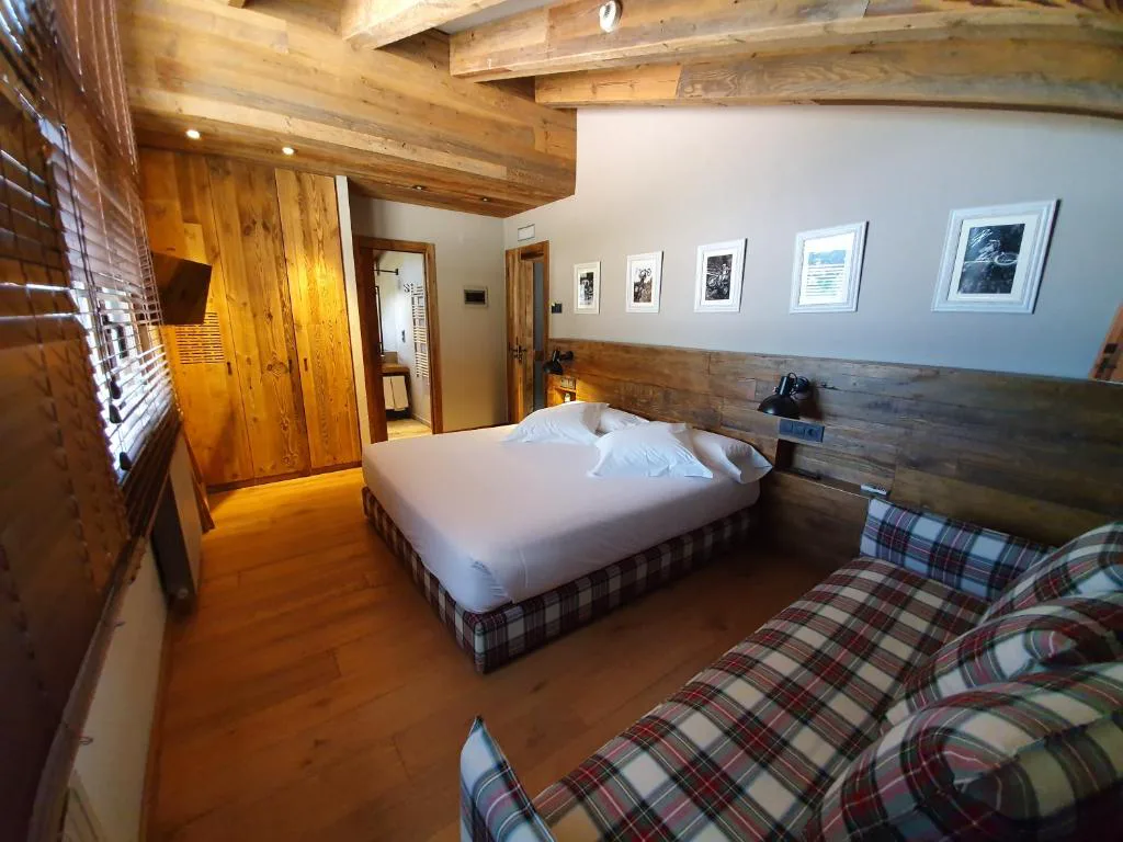 Habitación con cama y sofá de cuadros