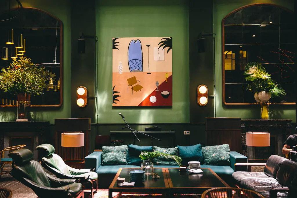 Salón con sofás verdes y cuadros de colores