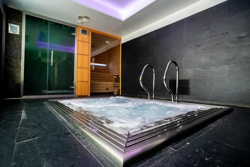 Jacuzzi en una sala de spa con luz tenue
