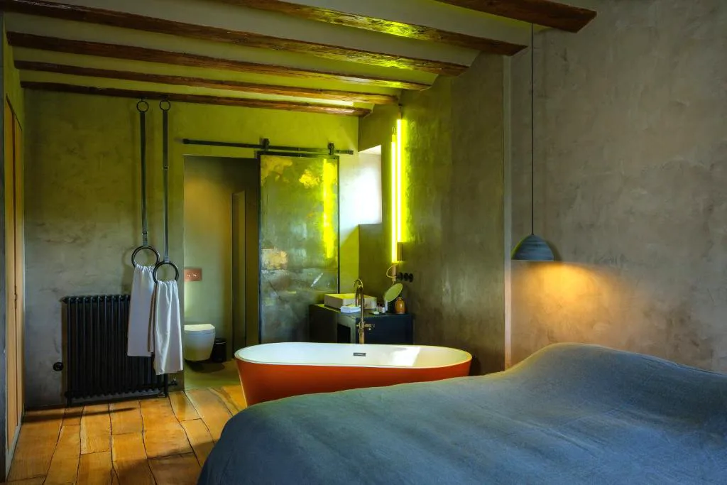 Habitación con bañera junto a la cama