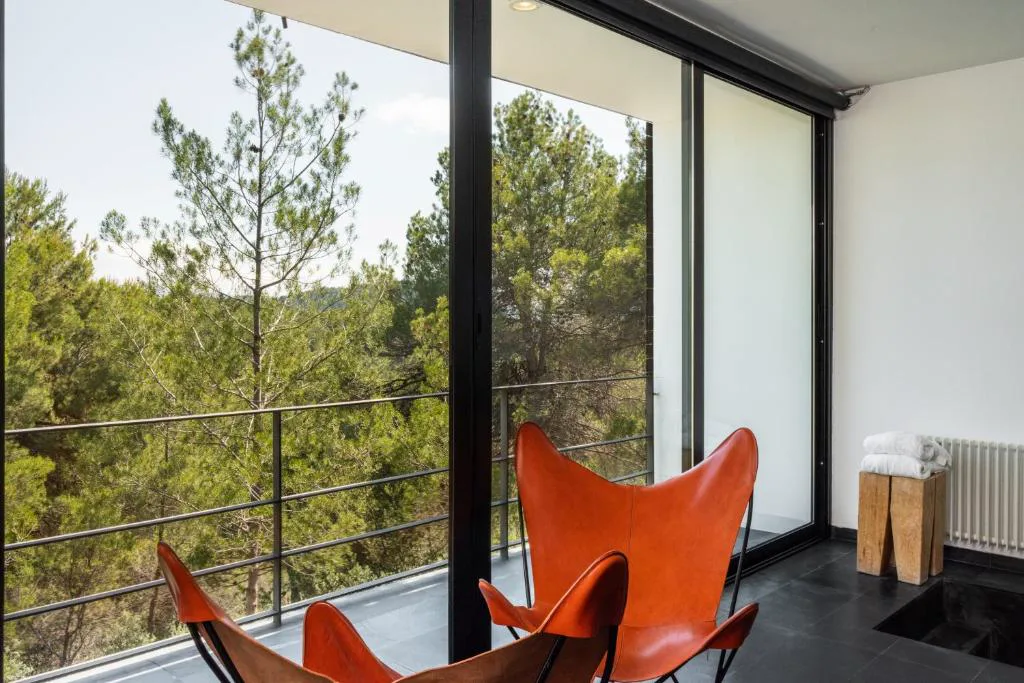 Habitación con ventanales y sillón naranja