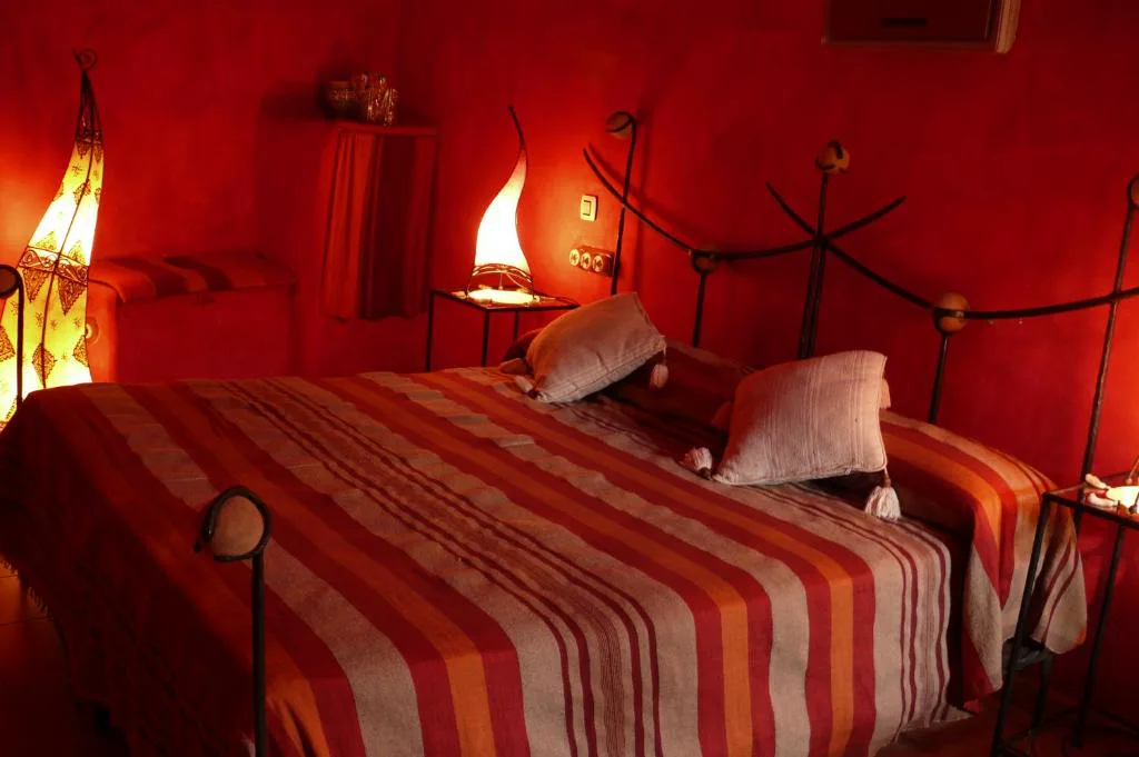 Habitación de paredes rojas y cama de forja