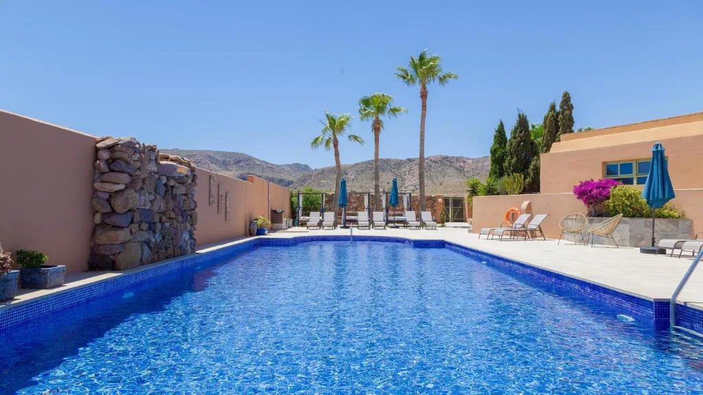 Piscina con cascada y palmeras en el patio central