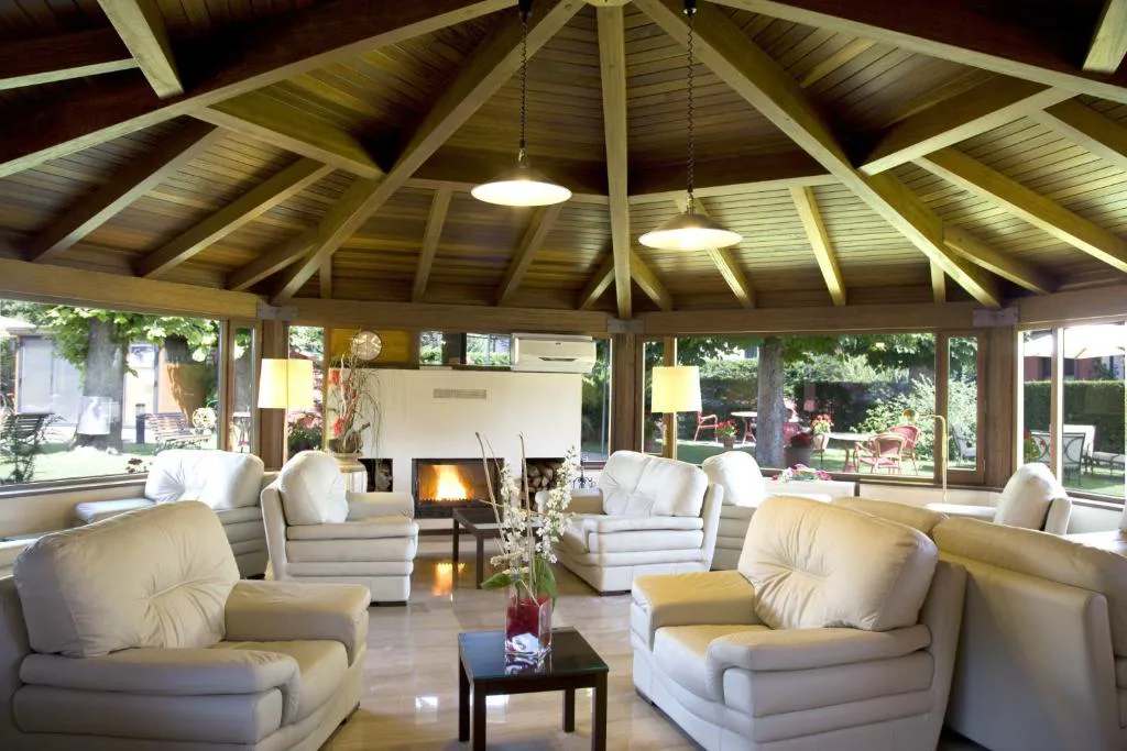 Salón con chimenea y sofás blancos bajo techo de madera