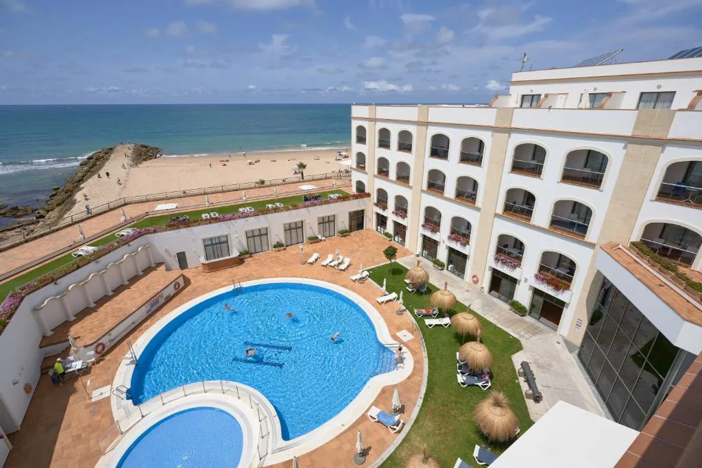 Vista aérea del hotel con piscina en forma de laguna junto al mar