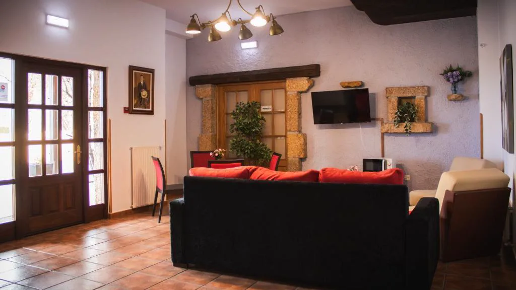 Salón con sofás negros y butacas rojas
