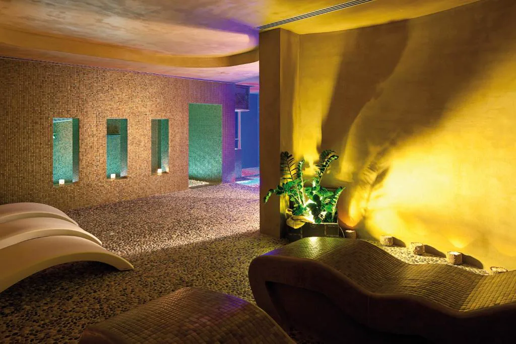 Sala de relax del spa con tumbonas curvas y paredes de mosaico, Hotel Es Marès