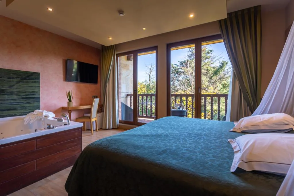 Habitación con bañera de hidromasaje junto a la cama