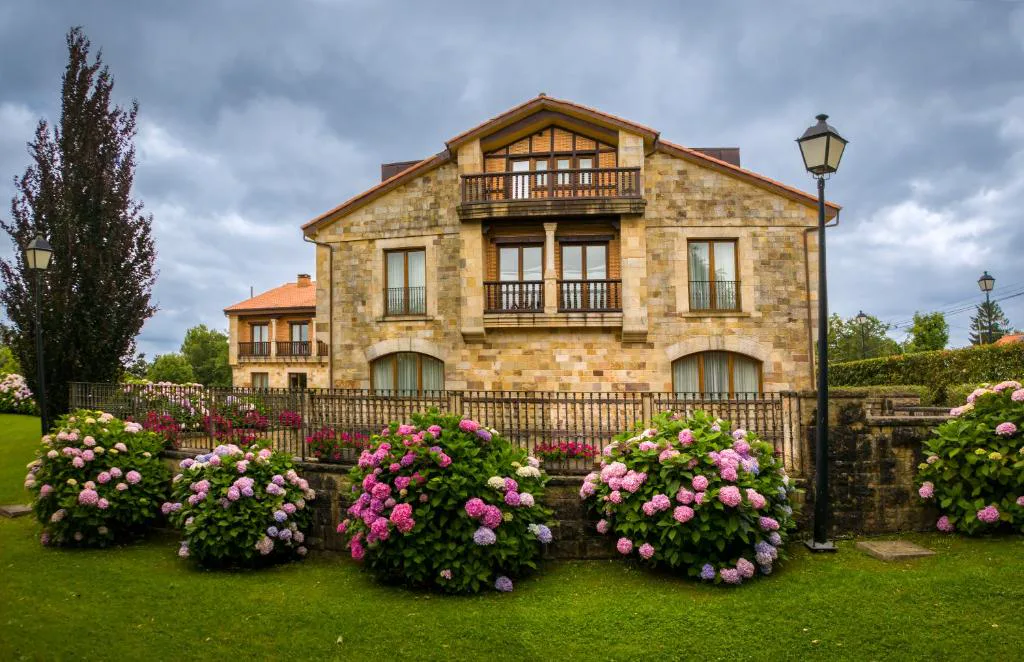 Hotel de piedra rodeado de hortensias