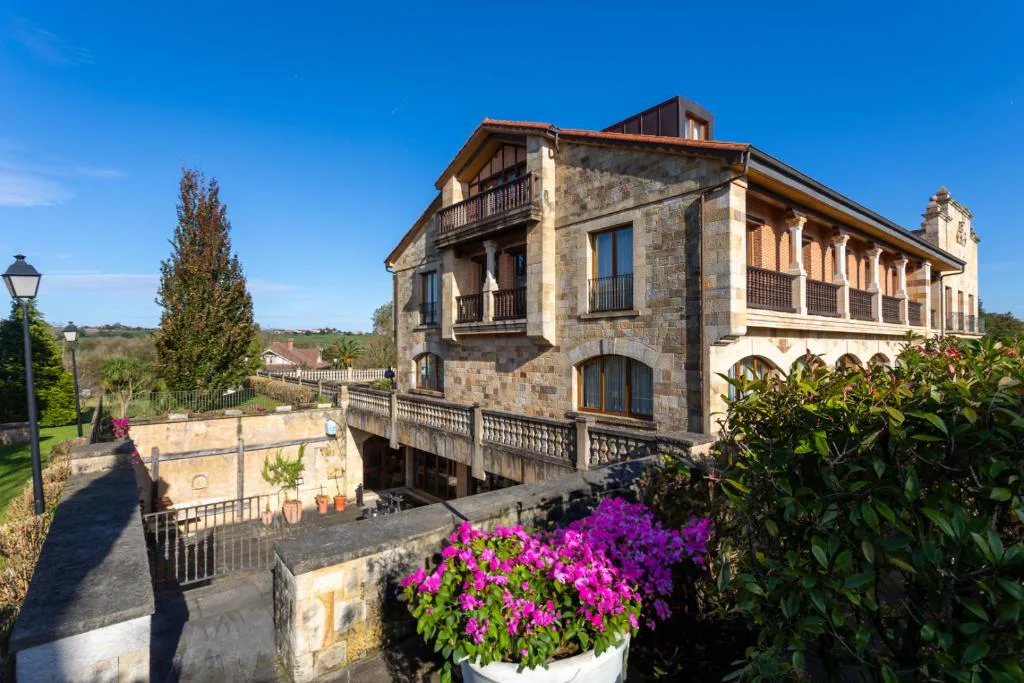 Hotel de piedra junto a un puente y flores