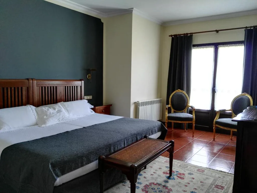 Habitación con cabecero de madera, cama doble y cortinas grises