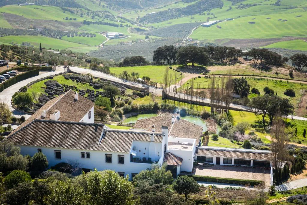 Vista aérea del hotel rural entre campos verdes en la ladera del Torcal