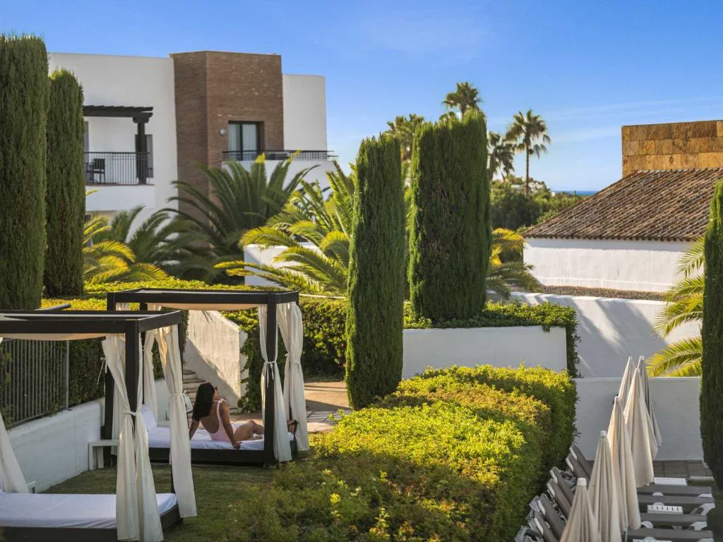 Jardín con cenadores blancos y setos