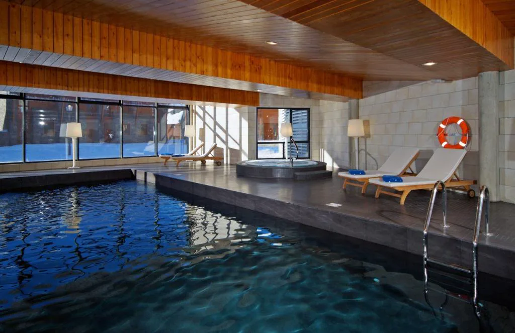 Piscina cubierta con escalera y ventanales