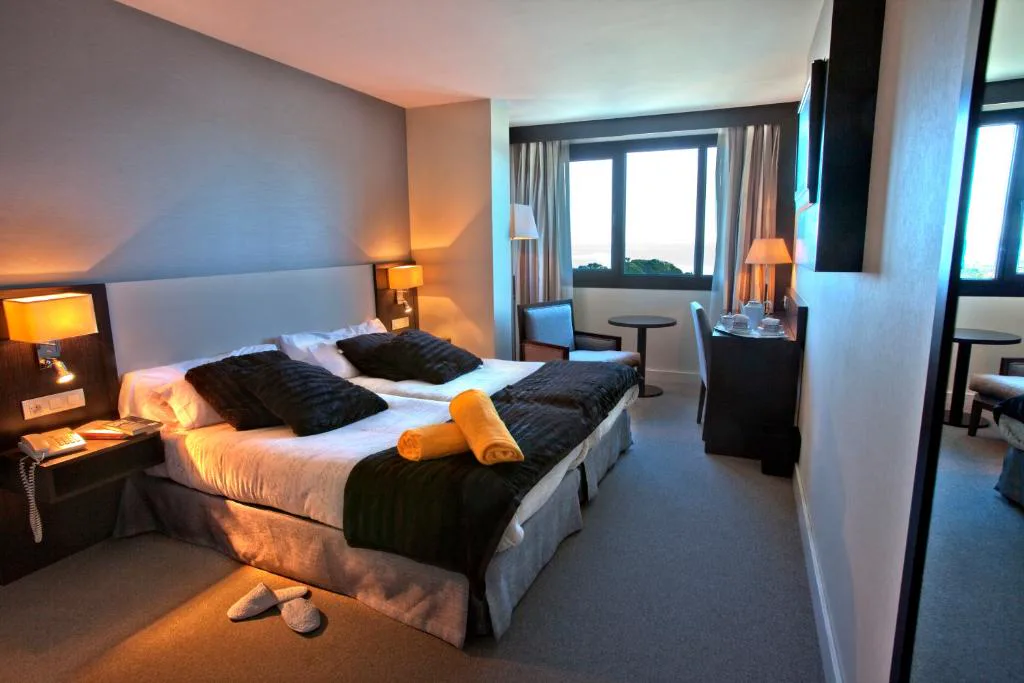 Habitación con cama grande y ventanales