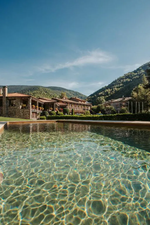 Piscina exterior de agua clara con montañas al fondo
