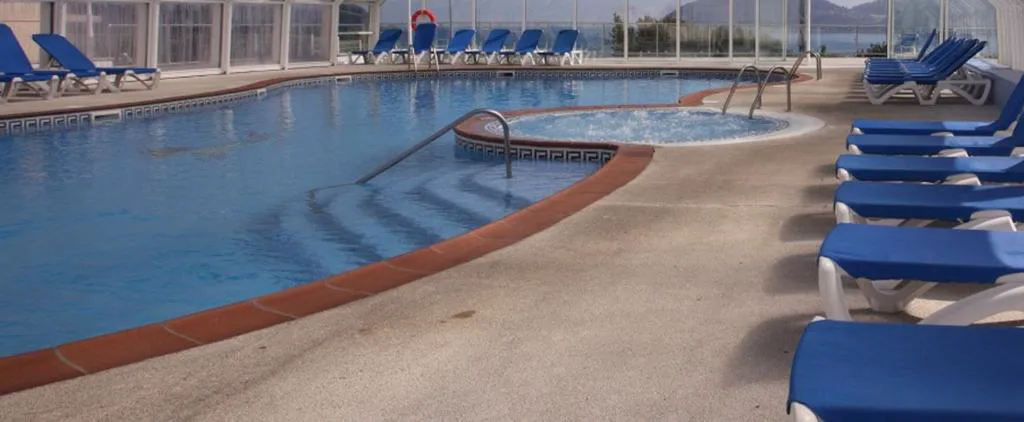Piscina cubierta con jacuzzi circular integrado y tumbonas, Hotel Las Sirenas, Viveiro