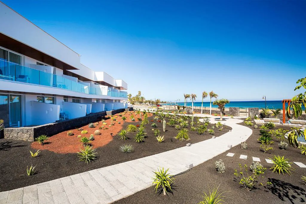 Fachada blanca del hotel junto al paseo marítimo de Puerto del Carmen