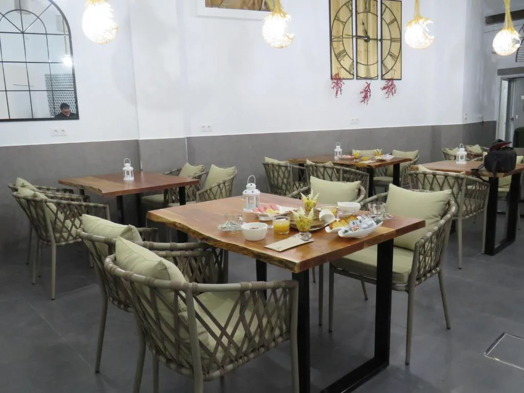 Sala de desayunos con mesas de madera y lámparas colgantes de fibra natural, Hotel Lua Boutique