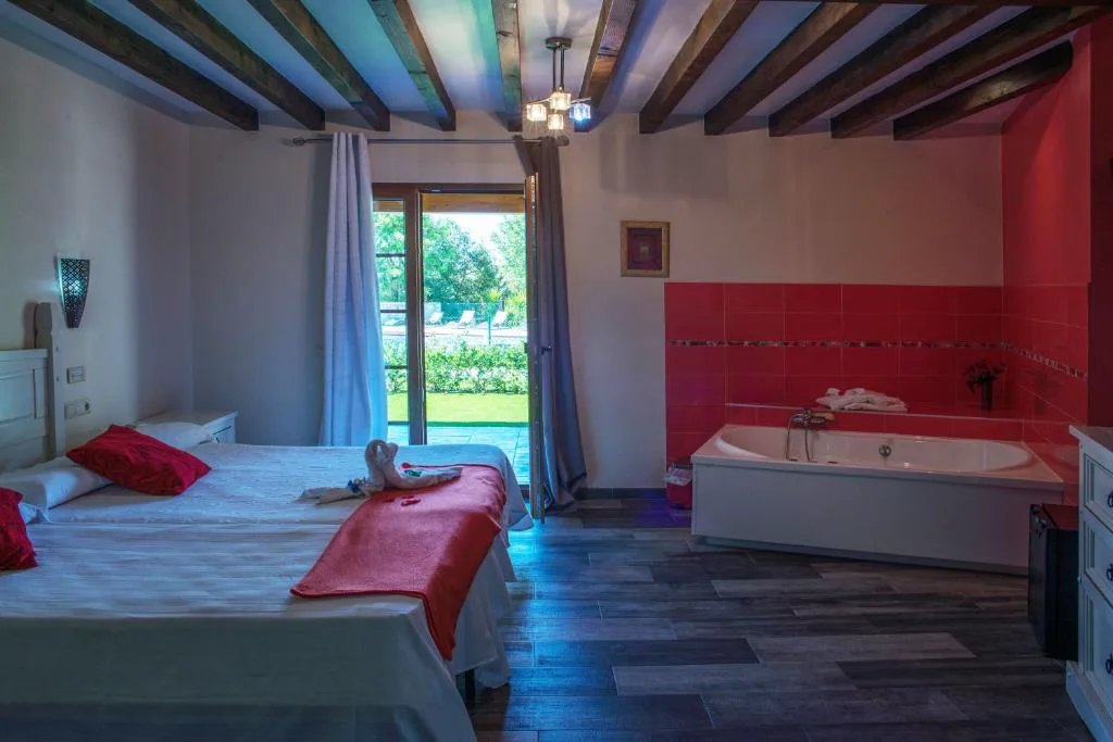 Habitación con bañera de hidromasaje junto a la cama