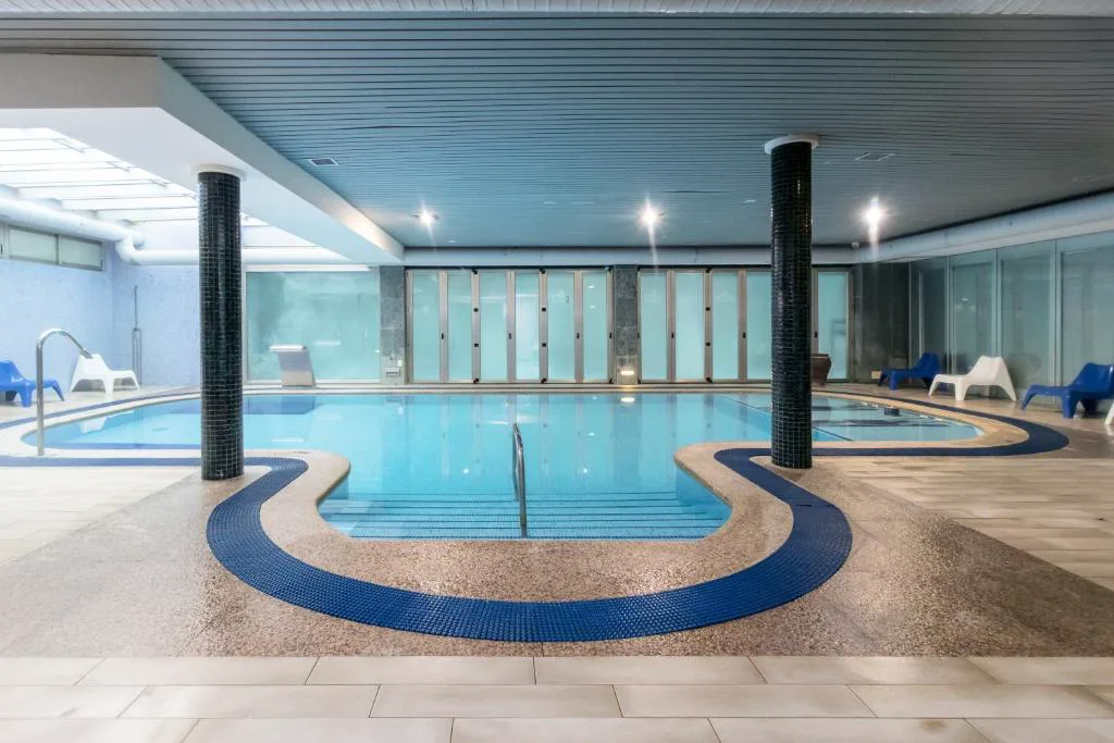 Piscina cubierta con columnas y cristaleras