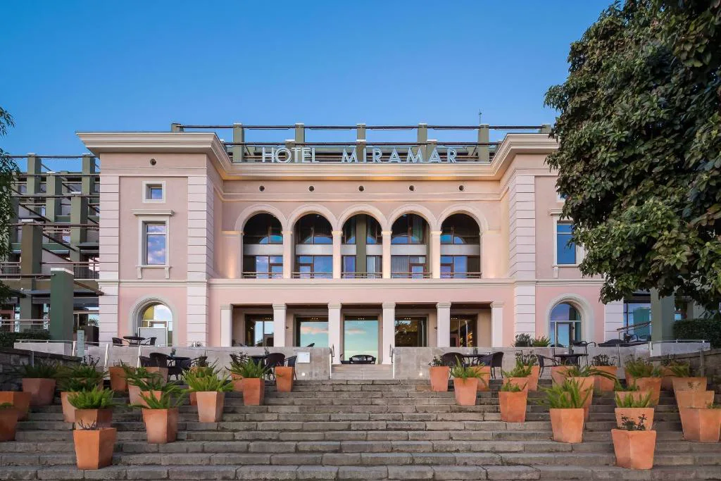 Edificio histórico rosado con escalinata y macetas