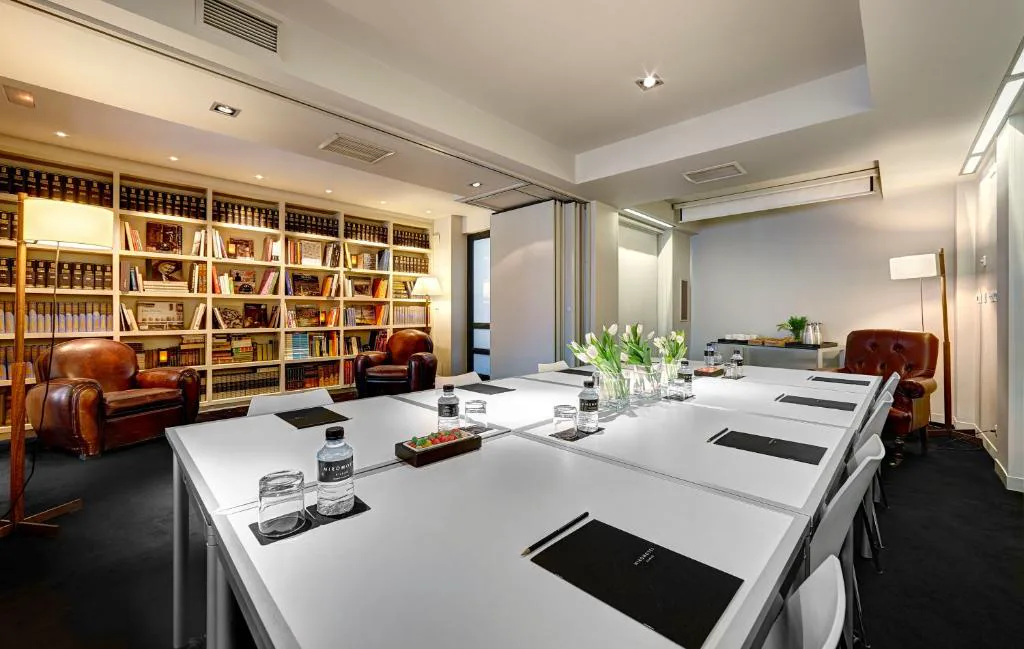Sala de reuniones con mesa blanca y librería