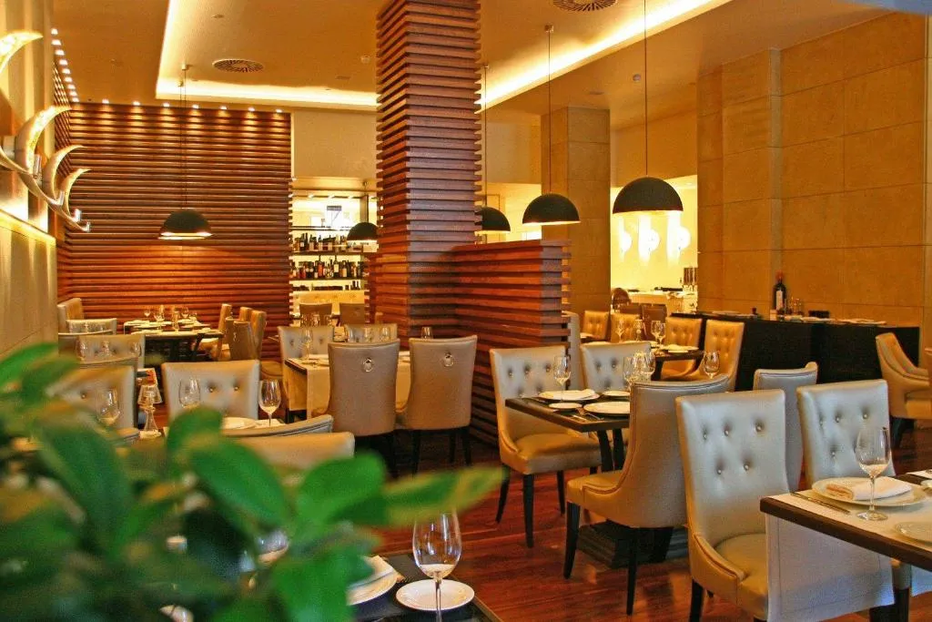 Restaurante del hotel con mesas vestidas y separadores de madera de diseño