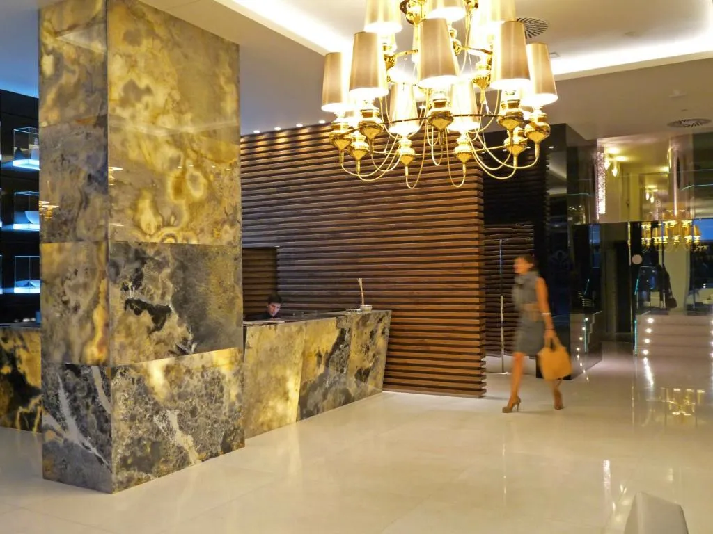 Recepción de mármol dorado y negro con lámpara de araña, Hotel Nagari
