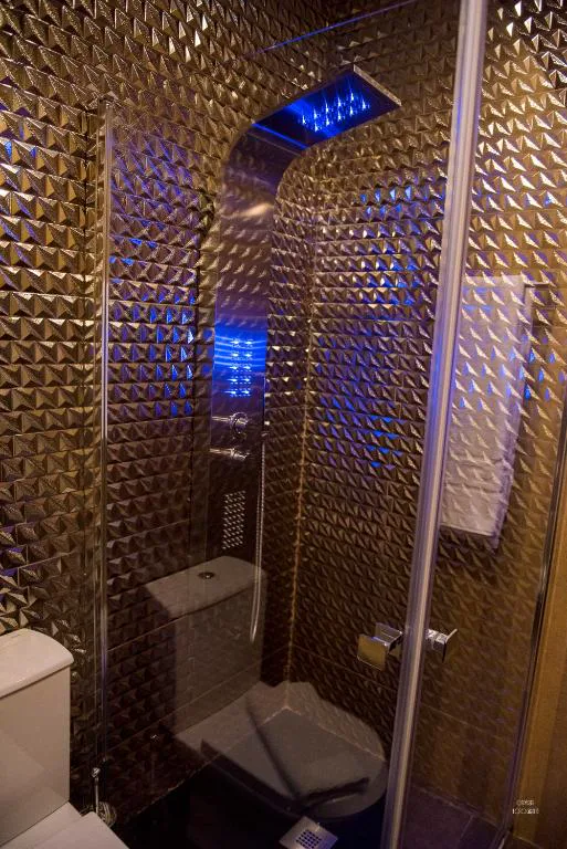 Ducha de diseño con paneles metálicos texturizados e iluminación azul, Hotel Naturaleza Mar da Ardora