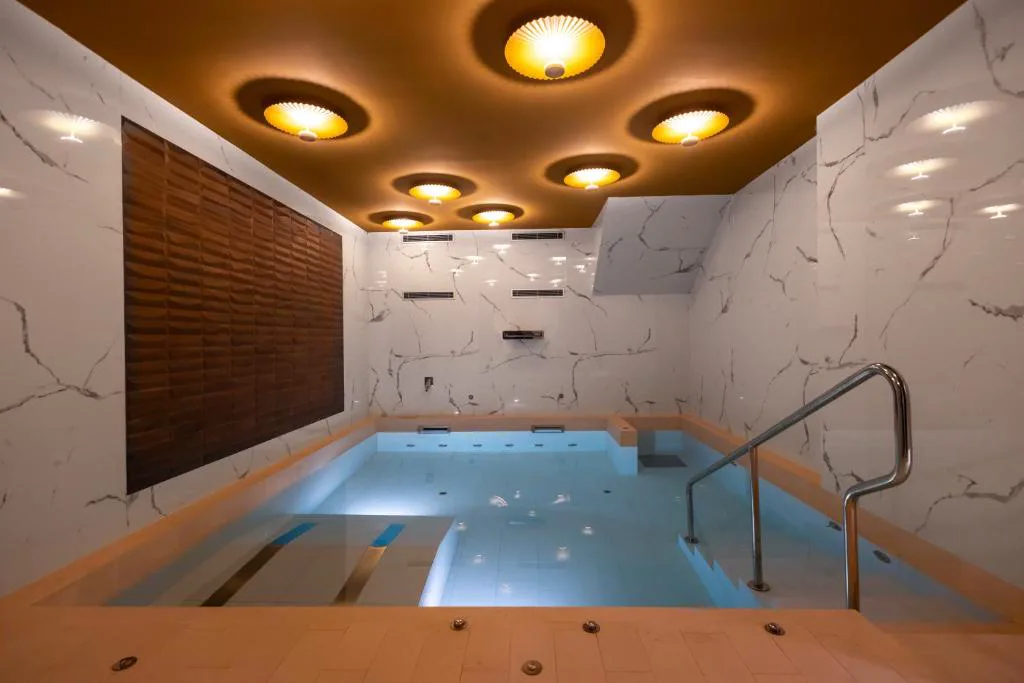 Piscina de spa con escalones y techo de focos dorados