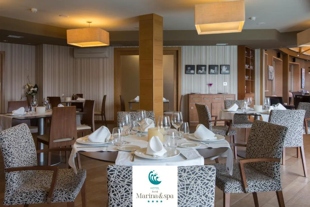 Salón del restaurante con mesas redondas vestidas y ambiente íntimo, Hotel Norat Marina & Spa