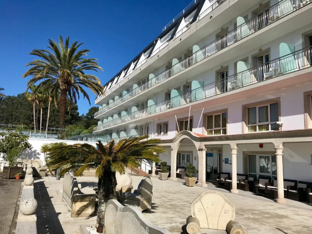 Fachada principal con entrada porticada y palmeras, Hotel Nuevo Vichona