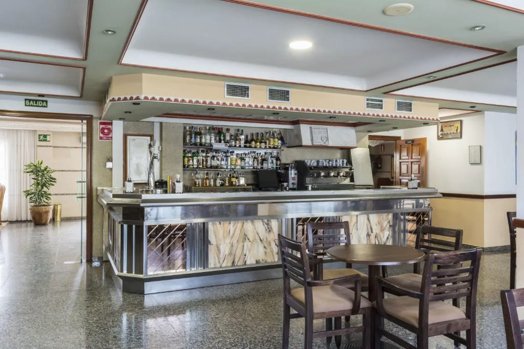 Bar del hotel con barra de mármol y estantería de licores, Hotel Nuevo Vichona