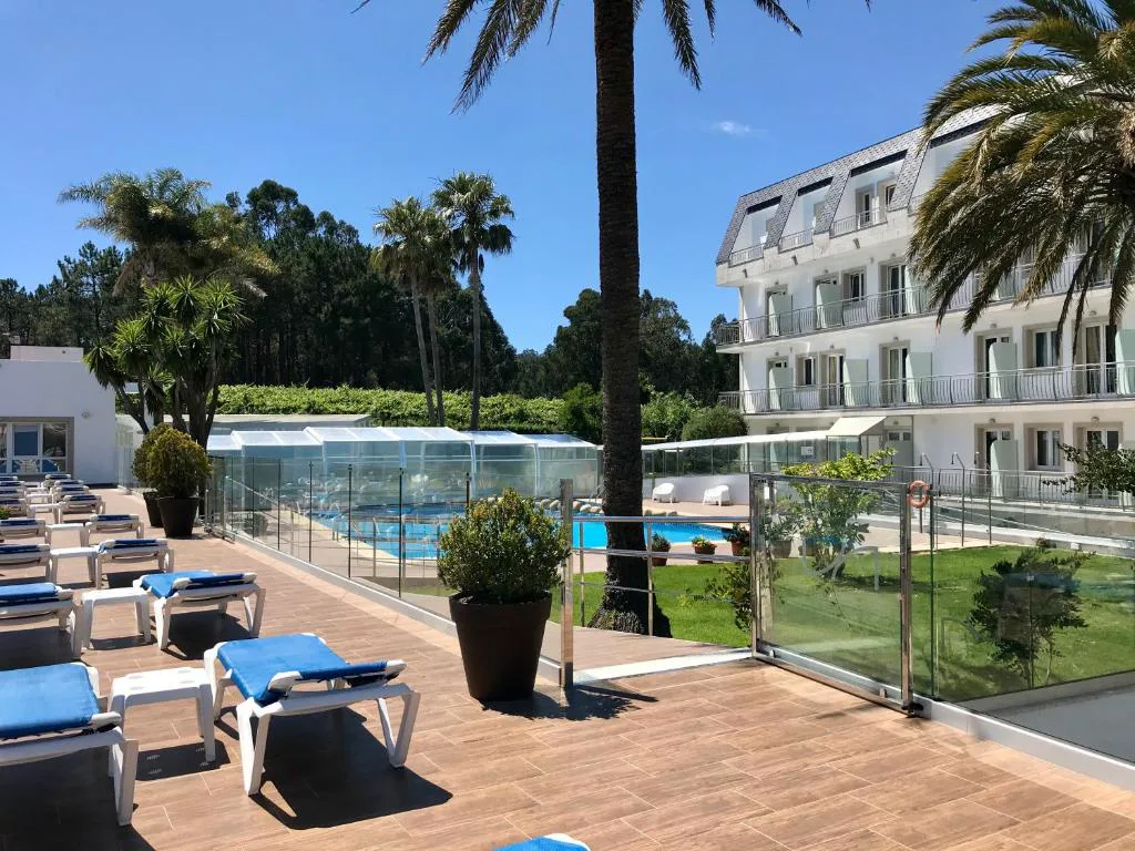 Terraza con tumbonas y vistas a las dos piscinas del hotel entre palmeras, Hotel Nuevo Vichona