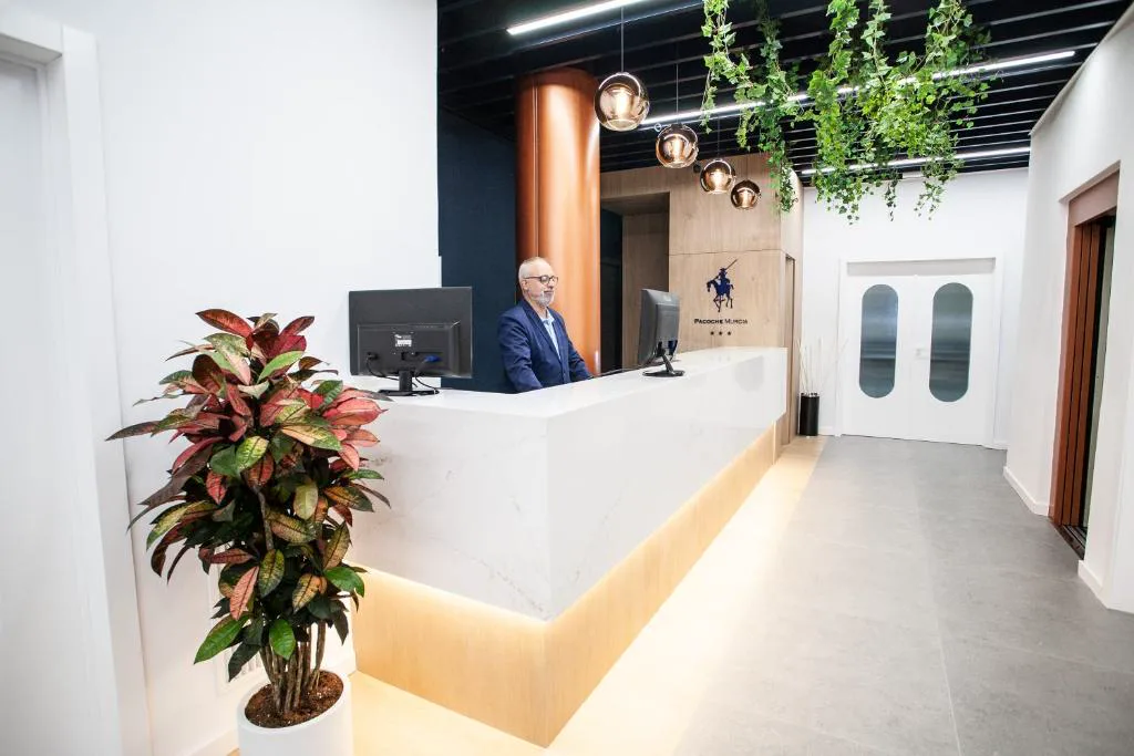 Recepción con mostrador iluminado y plantas