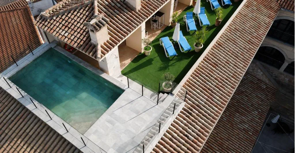 Vista aérea de la piscina entre tejados y patios del palacio