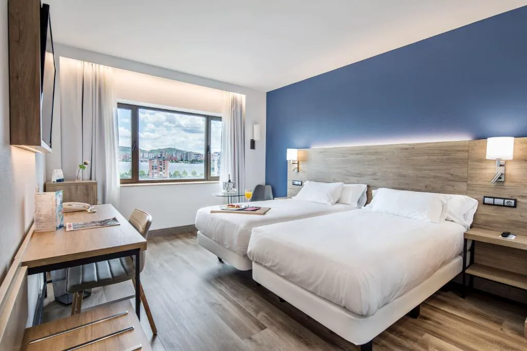 Habitación con cabecero azul y ventana