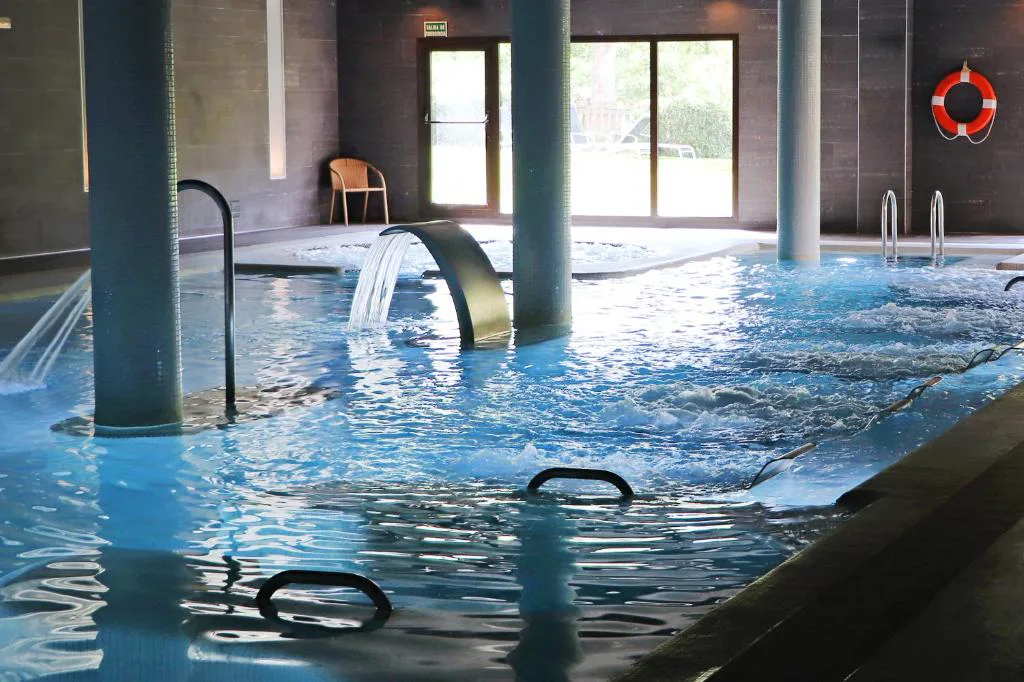 Piscina termal con cascada cervical en un balneario