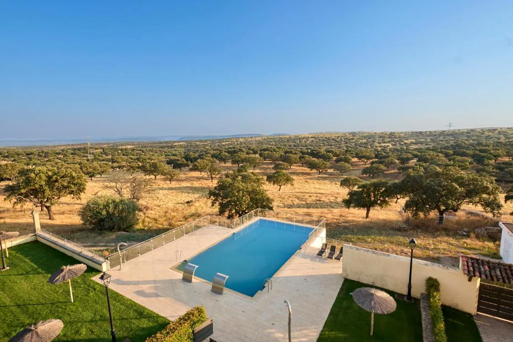 Vista de la dehesa con piscina y casas