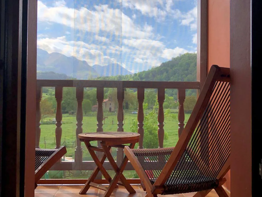 Balcón de madera con sillas y vistas a las montañas