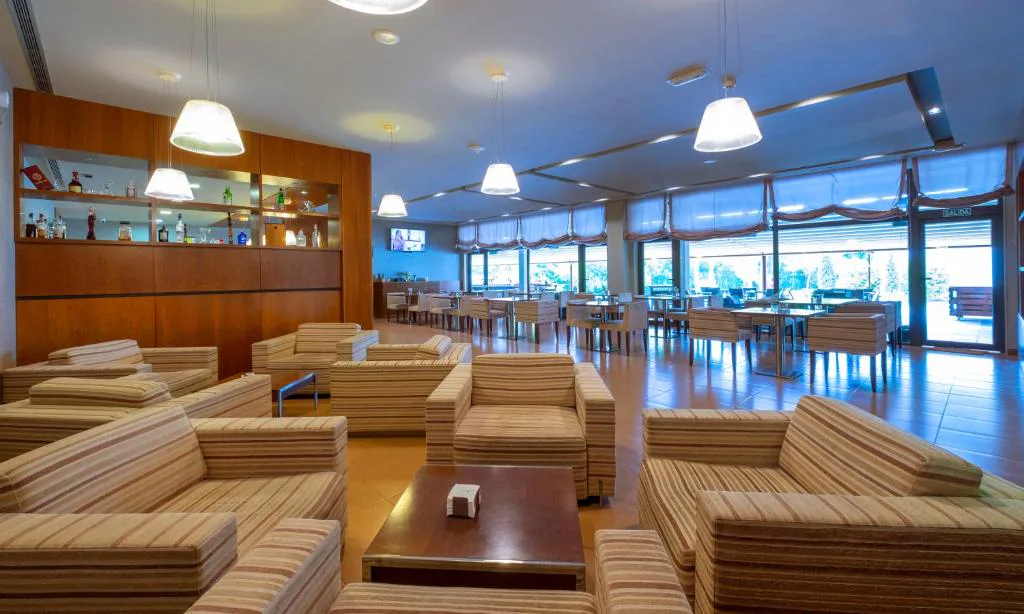 Bar y zona de estar con sofás a rayas junto al comedor, Hotel Spa Attica21 Vilalba